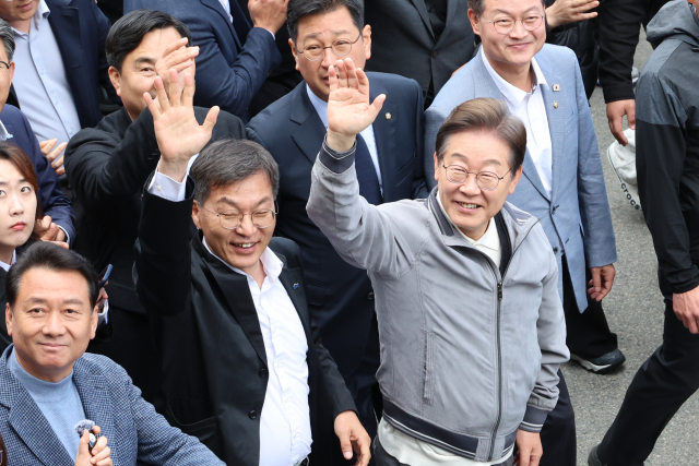 이재명(오른쪽) 더불어민주당 대선 후보가 3일 '골목골목 경청투어' 사흘째인 3일 강원도 동해안 지역의 민심을 공략하기 위해 강릉 안목해변 커피거리를 찾아 도민과 관광객들을 향해 인사하고 있다.연합뉴스