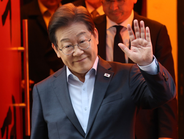 이재명 더불어민주당 대선 후보가 1일 서울 종로구의 한 포차 식당에서 '당신의 하루를 만드는, 보이지 않는 영웅들'이란 주제로 열린 배달 라이더, 택배 기사 등 비(非)전형 노동자들과 간담회를 마친 뒤 이동하며 손인