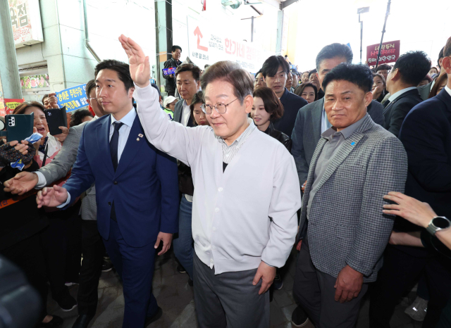 이재명(가운데) 더불어민주당 대선 후보가 7일 전북 임실군 임실시장에서 지역 주민들에게 손을 들어 인사하고 있다. 연합뉴스