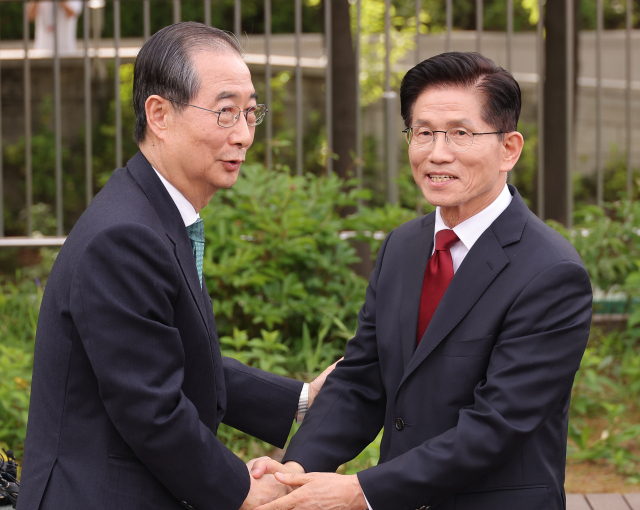 김문수(오른쪽) 국민의힘 대선 후보와 한덕수 무소속 대선 예비후보가 8일 서울 국회 사랑재에서 만나 악수하고 있다. 연합뉴스