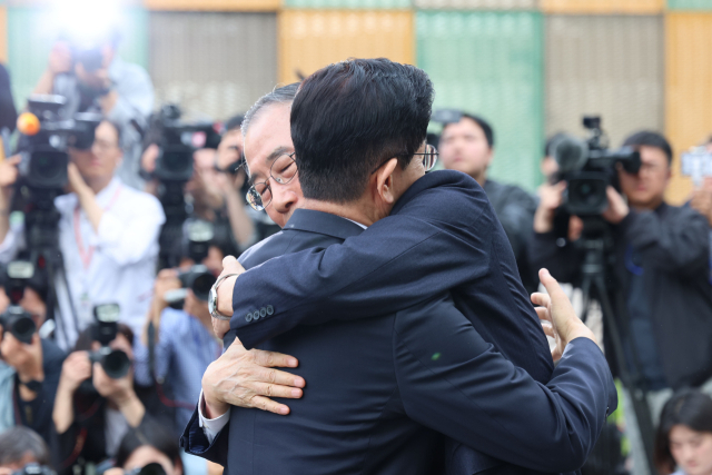 국민의힘 김문수 대선후보와 무소속 한덕수 대선 예비후보가 8일 서울 국회 사랑재에 위치한 커피숍에서 회동을 마친 후 포옹하고 있다. 연합뉴스