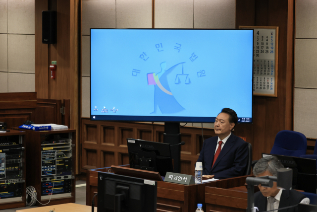 윤석열 전 대통령이 지난달 21일 서울 서초구 서울중앙지법에서 열린 내란 우두머리 혐의 형사재판 2차 공판에 출석해 있다. 사진공동취재단