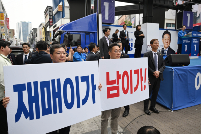 이재명 더불어민주당 대선 후보가 13일 대구 중구 동성로에서 유권자들에게 지지를 호소하고 있는 가운데 선거운동원들이 '재매이가 남이가!'라는 피켓을 들고 있다. 대구=오승현 기자