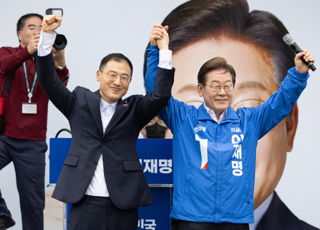 이재명 더불어민주당 대선후보가 16일 전북 익산시 익산역 동부광장에서 열린 유세에서 김상욱 무소속 의원과 손을 들어 인사하고 있다.연합뉴스