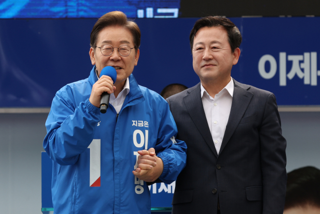 이재명 더불어민주당 대선후보가 17일 광주광역시 서구 김대중컨벤션센터 광장에서 열린 집중 유세에서 이 후보 지지를 선언한 김용남 전 새누리당 의원을 소개하고 있다. 연합뉴스