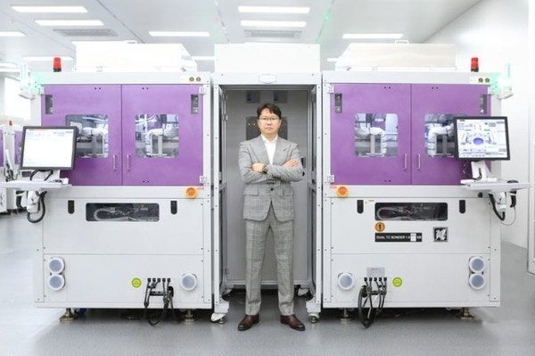 곽동신 한미반도체 회장과 회사의 TC 본더. 사진제공=한미반도체