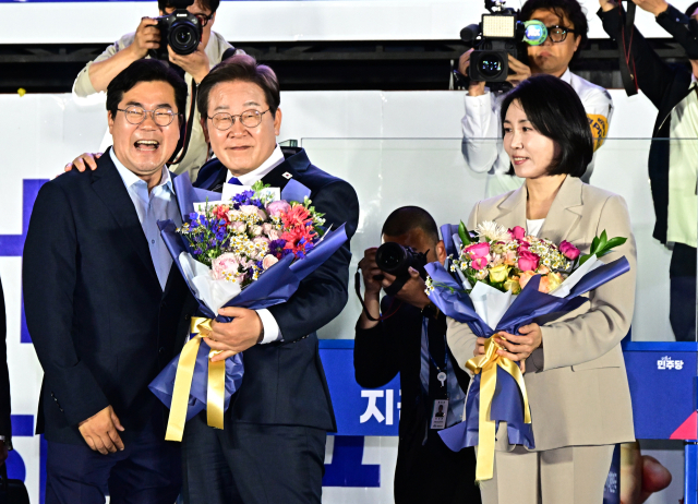 당선이 확실시된 이재명 더불어민주당 대선 후보가 김혜경 여사와 4일 오전 서울 여의도 국회 앞을 찾아 박찬대 상임총괄선대본부장으로부터 꽃다발을 받고 있다. 뉴스1