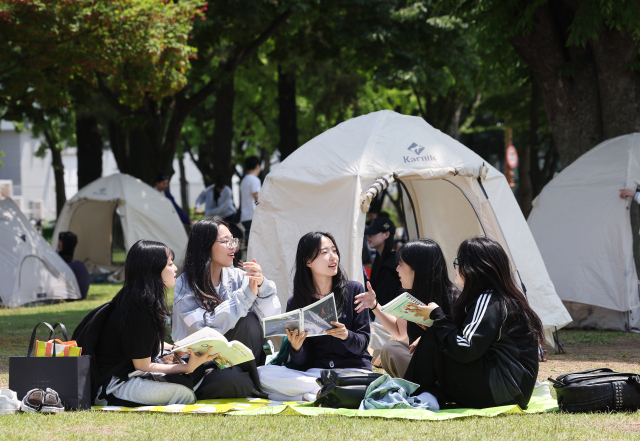 서울 시내 한 대학 캠퍼스 잔디밭에서 학생들이 책을 읽고 있다. 연합뉴스