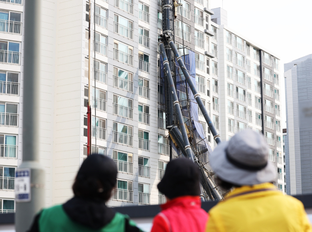 6일 경기도 용인시 기흥구 한 공사 현장에서 대형 건설 기계가 넘어져 인근 아파트 벽면에 쓰러져 있다. 연합뉴스