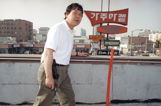1992년 ‘로스앤젤레스 폭동’ 당시 LA 코리아타운에 있는 식료품점 주인 리처드 리가 권총을 들고 옥상에서 경계를 서고 있다. AP 연합뉴스