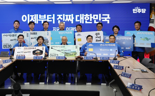 지난달 21일 서울 여의도 당사에서 열린 중앙선거대책위원회의에서 더불어민주당 윤여준 총괄선대위원장을 비롯한 참석자들이 지역화폐 활성화를 촉구하는 퍼포먼스를 하고 있다. 연합뉴스.