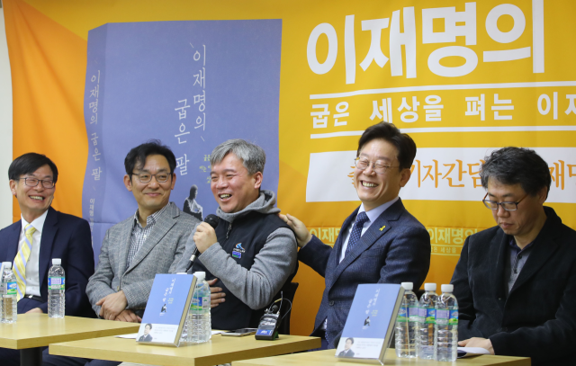 이재명 대통령이 2017년 2월 8일 서울 중구 환경재단 레이첼카슨홀에서 열린 '이재명의 굽은 팔' 출판 간담회에서 김영훈(왼쪽 세 번째) 고용노동부 장관 후보자의 발언을 듣던 중 활짝 웃고 있다. 김 후보자는 이명