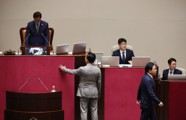 여당인 더불어민주당의 일방적 요청으로 27일 국회 본회의가 열려 법사위원장 선출 안건 등이 강행 처리되려 하자 송언석(앞줄 오른쪽) 국민의힘 원내대표가 우원식(뒷줄 왼쪽) 국회의장에게 항의하다가 퇴장하고 있다. 연합
