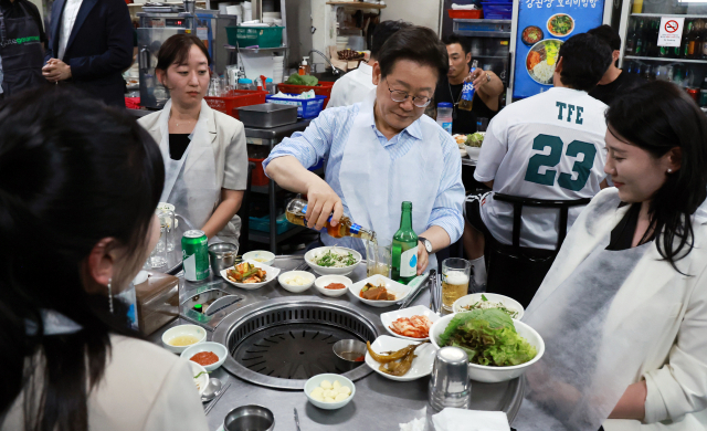 이재명 대통령이 11일 저녁 서울 광화문 인근 한식당에서 대통령실 직원들과 회삭하며 ‘소맥’을 직접 만들고 있다. 연합뉴스