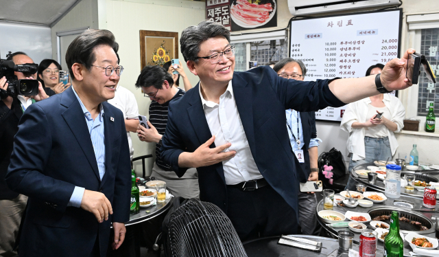 이재명 대통령이 11일 저녁 서울 광화문 인근 한식당에서 만난 시민과 기념 촬영을 하고 있다. 연합뉴스