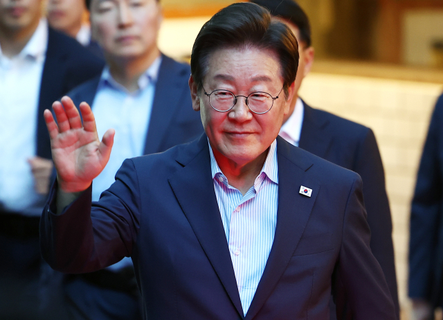 이재명 대통령이 11일 저녁 서울 광화문 인근 한식당에서 나오며 시민들에게 손을 흔들고 있다. 이 대통령은 식당을 찾기 전 SNS에 식사 계획을 알리며 "민생회복 소비쿠폰 정책이 내수 진작과 지역경제 활성화에 활력을