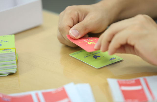 광주 북구 한 행정복지센터에서 공무원들이 소비쿠폰 현물카드에 스티커를 붙여 색상을 교체하고 있다. 연합뉴스