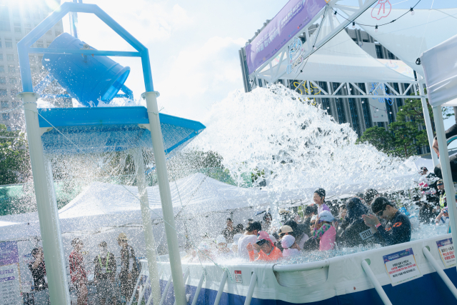 서울 광화문광장에 마련된 ‘2025 서울썸머비치’를 찾은 시민들이 물놀이를 즐기고 있다. 사진 제공=서울관광재단