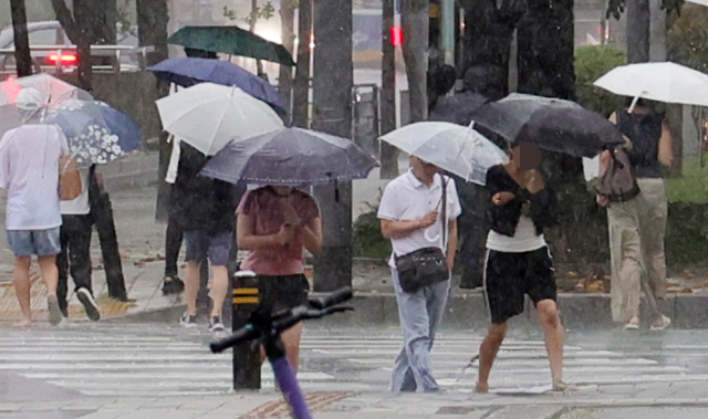 비가 내리는 16일 오후 경기도 고양시내에서 시민들이 우산을 쓰고도 흠뻑 젖은 채 횡단보도를 건너고 있다. 연합뉴스