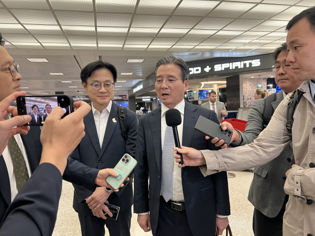 김용범(가운데) 대통령실 정책실장이 16일(현지 시간) 워싱턴DC 덜레스국제공항에 도착해 기자들의 질문에 답하고 있다. 이태규 특파원.