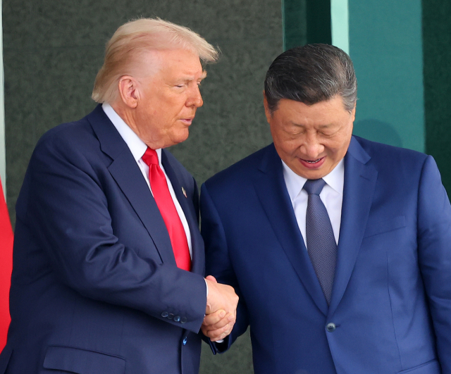 도널드 트럼프(왼쪽) 미국 대통령과 시진핑 중국 국가주석이 지난달 30일 부산 김해공군기지 의전실 나래마루에서 미중 정상회담을 마친 뒤 회담장을 나서며 악수하고 있다. 연합뉴스
