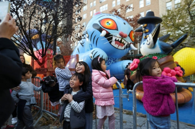 27일(현지시간) 더피와 서씨 풍선 앞에서 사진을 찍기 위해 포즈를 취하고 있는 아이들. 로이터 연합뉴스