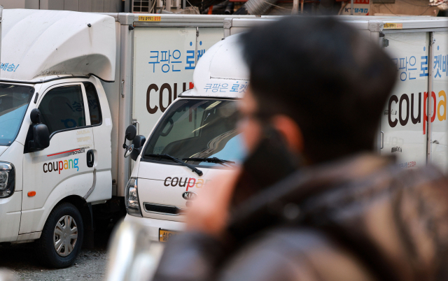 이커머스 1위 업체 쿠팡에서 약 3400만건의 대규모 개인정보 유출 사태가 발생한 가운데 4일 서울 시내의 한 쿠팡 물류센터 내 배송 차량 앞으로 시민이 걸어가고 있다. 연합뉴스