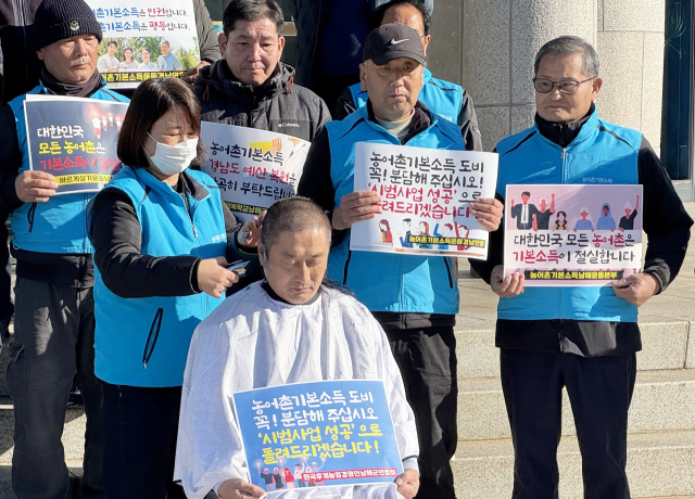 류경완(가운데) 경남도의원이 9일 경남도의회 앞에서 남해군 농어촌 기본소득 도비 126억원 복원을 요청하며 삭발을 하고 있다.연합뉴스