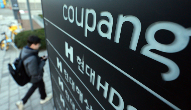 경찰이 고객 3370만명의 개인정보가 유출된 쿠팡에 대한 강제 수사에 나선 9일 서울 송파구 쿠팡 본사 사무실 입구 현판 앞으로 시민이 지나가고 있다.연합뉴스