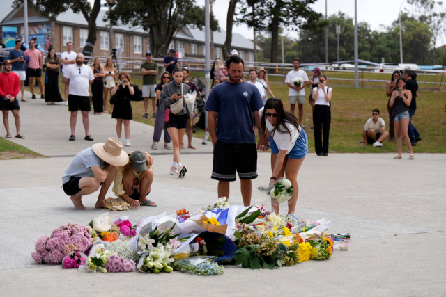 시드니 본디 비치에서 발생한 총격 사건 하루 뒤인 15일(현지 시간) 희생자들을 추모하기 위해 모인 사람들이 현장 인근에 꽃과 이스라엘 국기를 가져다 놓으며 애도하고 있다./AP연합뉴스