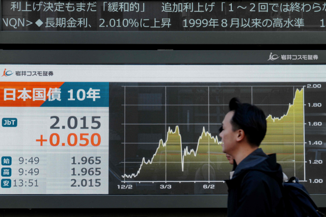 일본은행이 기준금리를 30년 만에 최고 수준인 0.75%로 올린 19일 한 시민이 일본 국채 10년물 금리를 표시한 전광판 앞을 지나가고 있다. 이날 도쿄 채권시장에서 일본 10년