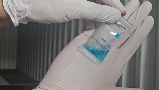 부산세관 검사 직원이 마약탐지키트를 통해 꾸러미 속 물질에서 코카인 반응을 확인하고 있다.사진제공=부산본부세관