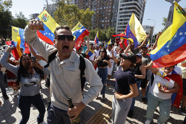 3일(현지 시간) 칠레 산티아고에서 베네수엘라 이주민들이 니콜라스 마두로 베네수엘라 대통령이 미군에 체포됐다는 소식에 환호하고 있다.EPA연합뉴스