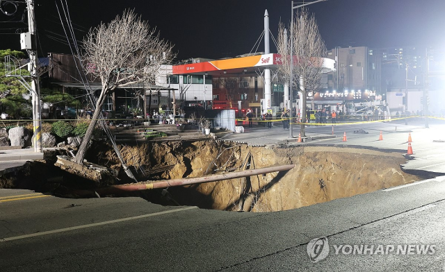 지난해 3월 싱크홀(땅 꺼짐) 사고가 발생한 서울 강동구 대명초등학교 인근 사거리에서 소방대원들이 현장 수색 및 구조작업을 준비하고 있다.연합뉴스