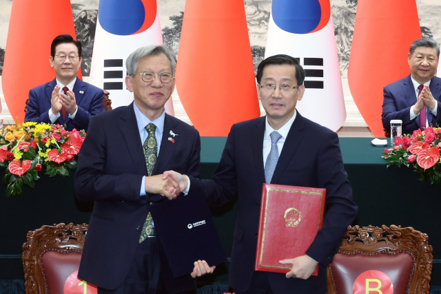 유홍준 국립중앙박물관장(왼쪽)과 라오취안 중국 국가문물국 국장이 5일 베이징 인민대회당에서 이재명 대통령과 시진핑 국가주석이 참석한 가운데 중국 청대 석사자상 한 쌍 기증 증서를 작성한 뒤 기념촬영을 하고 있다.연