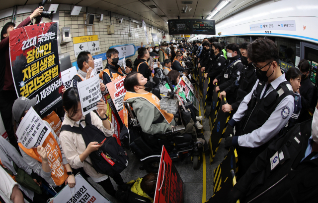 전국장애인차별철폐연대(전장연) 회원들이 경찰·서울교통공사 직원 등과 대치하고 있다.뉴스1