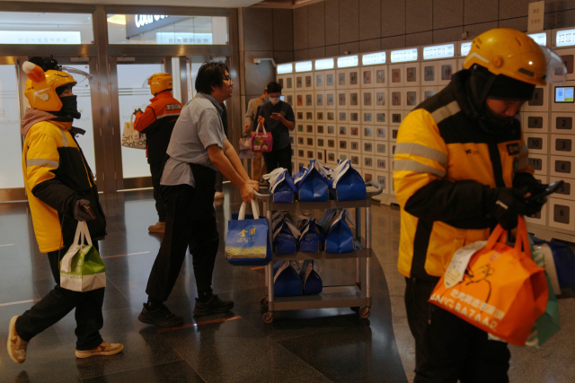 19일 베이징의 한 쇼핑몰 내 배달 픽업 박스에서 음식 배달 라이더들이 온라인 주문을 처리하고 있다.AP연합뉴스