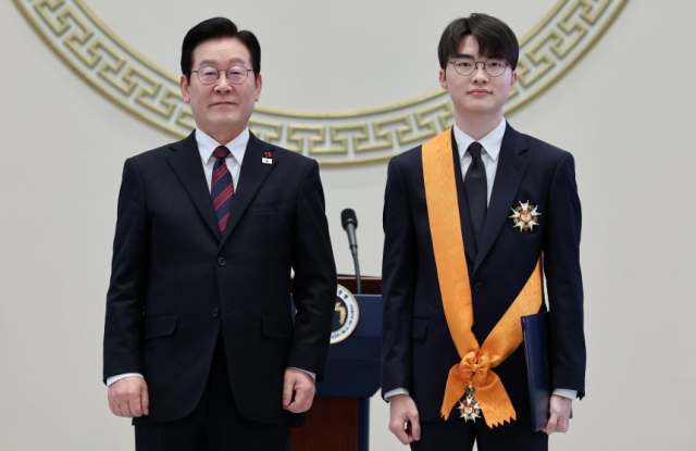 이재명 대통령이 청와대 영빈관에서 열린 2026년 신년 인사회에서 이상혁(페이커) 프로게이머에게 체육훈장 청룡장을 수여하고 기념촬영을 하고 있다. 뉴스1