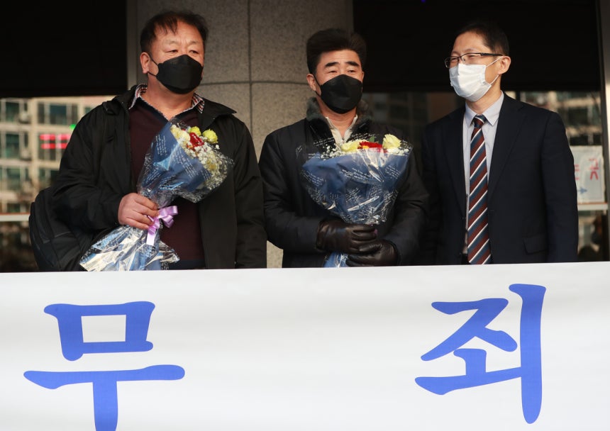 경찰 고문에 못 이겨 살인죄 누명을 쓴 채 21년간 억울한 옥살이를 한‘낙동강변 살인사건’피해 당사자 최인철(왼쪽)씨와 장동익씨가 2021년 2월 4일 오전 부산고등법원에서 열린 재심 선고 공판을 마치고 꽃다발을