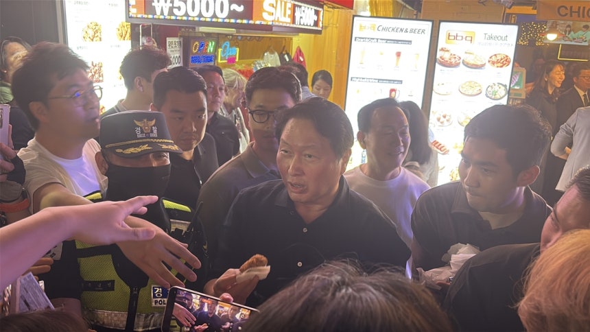 최태원 SK그룹 회장이 5일 젠슨 황 엔비디아 최고경영자(CEO)와 BBQ 홍대입구점에서 치맥 회동을 하던 중 밖으로 나와 시민들에게 치킨을 나눠주고 있다. 김태호 기자