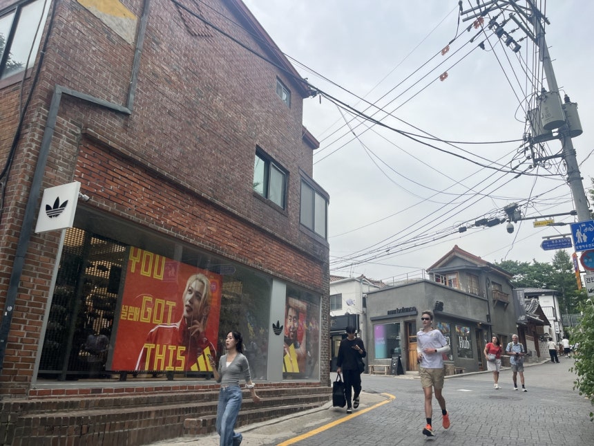 5일 서울 종로구 정독도서관 삼거리에서 바라본 북촌로5가길 초입에 아디다스 북촌 헤리티지점과 뉴발란스 북촌 허브가 마주한 채 시민과 외국인 관광객이 지나가고 있다. 정혜진기자
