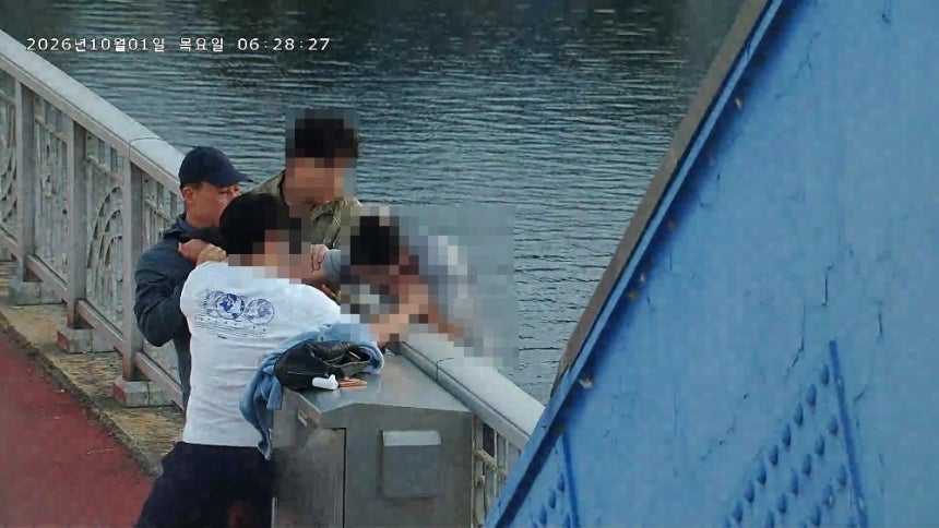 지난 1일 이재동 소방장비회계과장이 춘천시 소양2교에서 난간 밖 여성을 구조하는 모습.강원도소방본부 제공