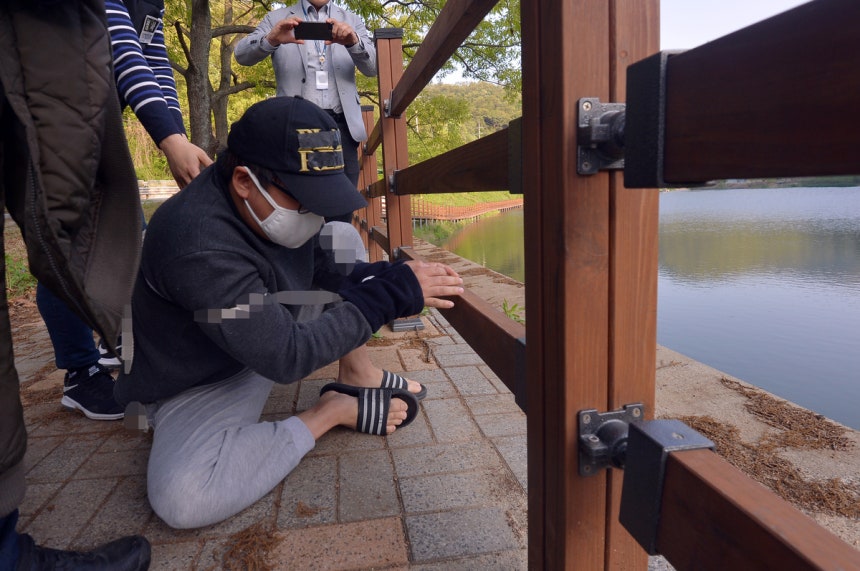 지난 2019년 5월 중학생 의붓딸을 살해하고 그 시신을 유기한 A씨(31)가 오후 광주 동구 한 저수지에서 시신유기 방법을 재연하고 있다.뉴스1