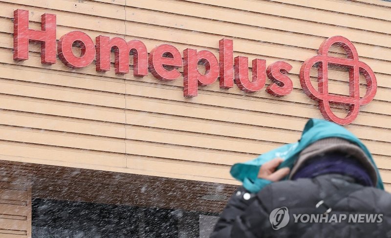 홈플러스 간판 앞에 행인이 서 있다.연합뉴스