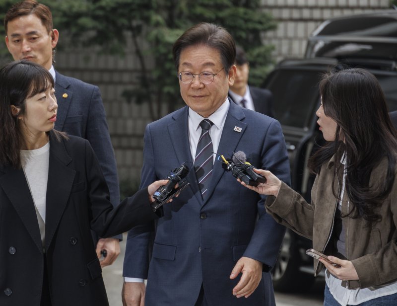 이재명 더불어민주당 대표(가운데)가 25일 서울 서초구 서울중앙지법에서 열린 '대장동·위례·백현동·성남FC사건' 1심 공판에 출석하다 취재진의 질문을 받고 있다. 이 대표는 26일 공직선거법 위반 사건의 항소심 판결