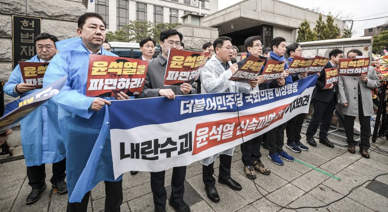 [서울=뉴시스] 정병혁 기자 = 27일 서울 종로구 헌법재판소 앞에서 열린 내란수괴 윤석열 신속파면 촉구 기자회견에서 더불어민주당 기획재정위원회, 정무위원회 소속 의원들이 피켓을 들고 있다. 2025.03.27. j