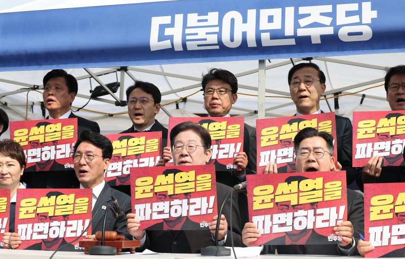 이재명 더불어민주당 대표(앞줄 왼쪽 두번째)를 비롯한 소속 의원들이 종로구 광화문 천막당사에서 윤대통령 파면을 촉구하는 모습. 뉴스1·연합뉴스
