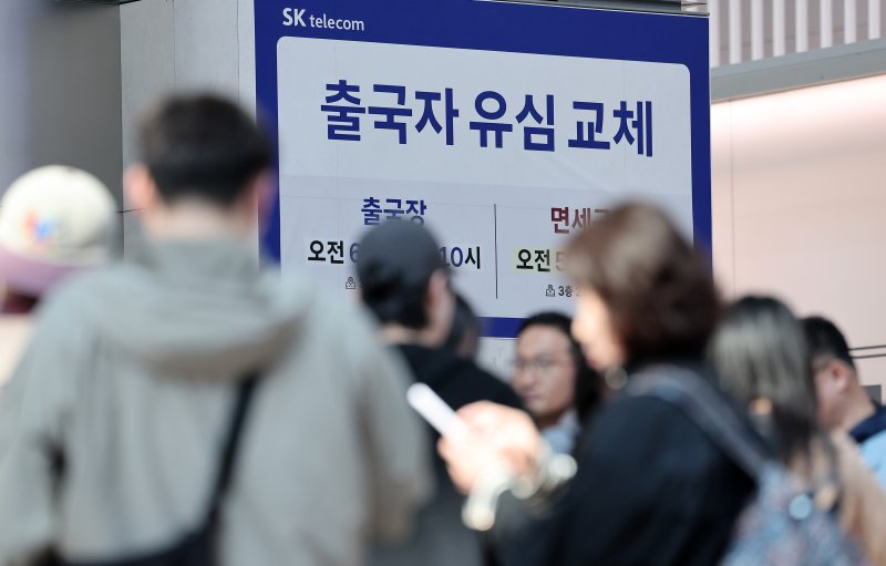지난 2일 오전 인천국제공항 제1여객터미널 출국장에 마련된 SK텔레콤 로밍센터에서 여행객들이 유심 교체 서비스를 받기 위해 대기하고 있다.뉴스1