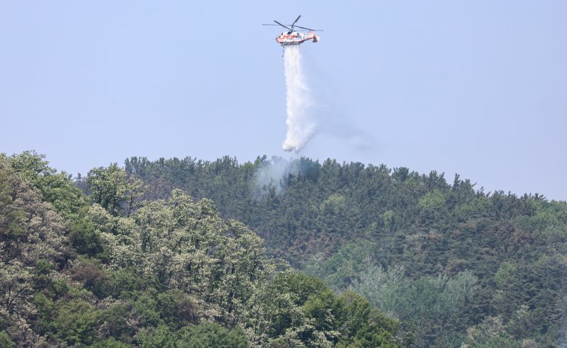 대구 북구 함지산 산불 이틀째인 지난달 29일 오후 산불 진화 작전에 투입된 산림청 헬기가 함지산 상공에서 물을 뿌리고 있다.뉴스1