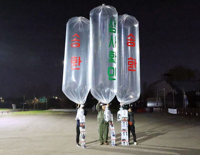 4월27일 오전 파주시 문산읍 임진각 평화랜드 펜스 뒤편에서 최성룡 납북자가족모임 대표(가운데)를 포함한 관계자들이 대북전단을 살포하고 있다.납북자가족모임 제공